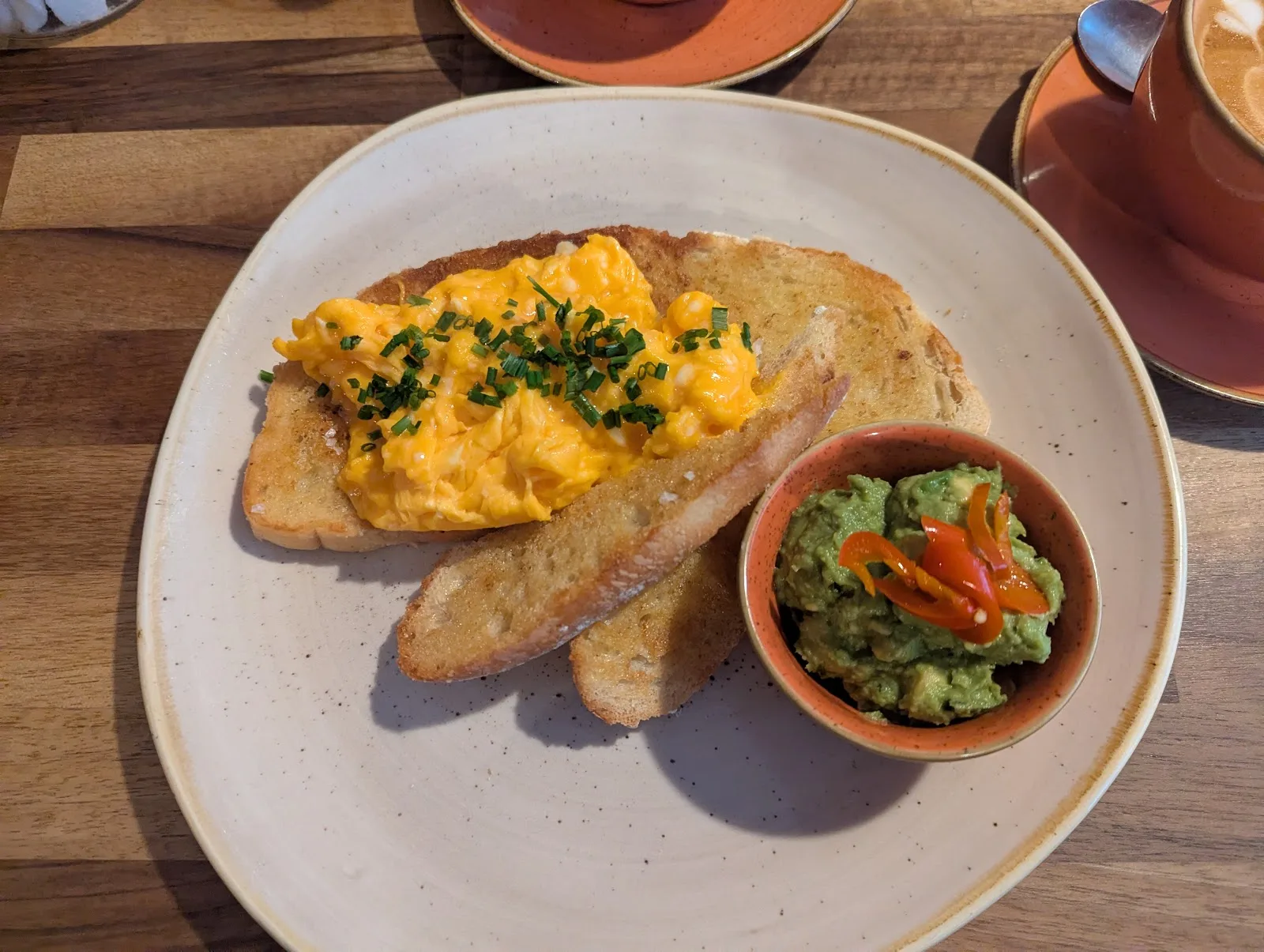 Scrambled eggs on toast with a pot of smashed avocado and chilli, with a latte, at Ethos, Havant