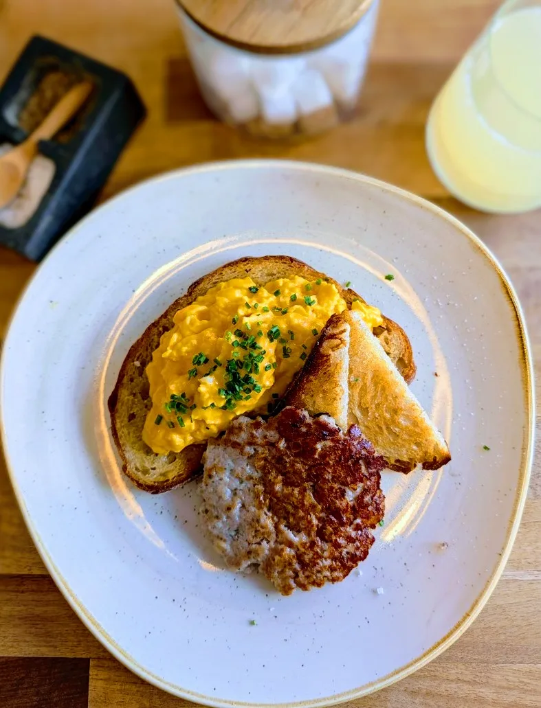 Scrambled eggs on toast with a sausage patty at Ethos, Havant